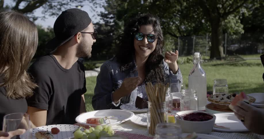 A group of young people laugh at a picnic