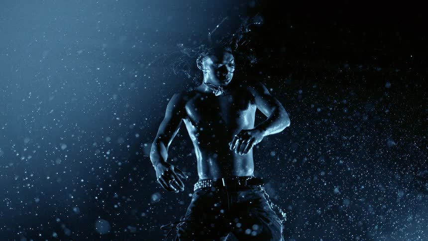 Bare chested man floating in a surreal environment of particles