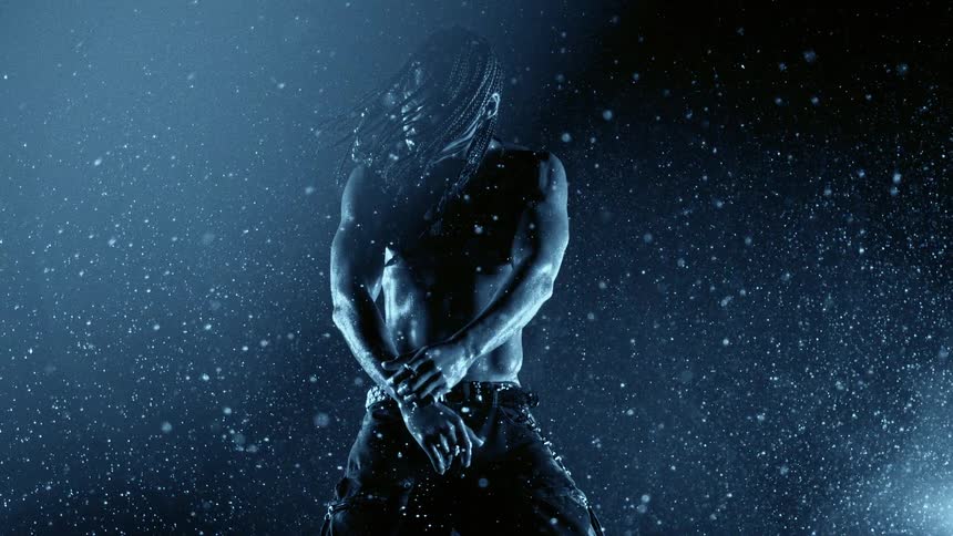 Shirtless person under heavy rain with visible droplets and blue lighting