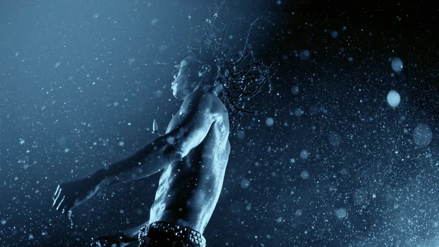 Bare chested man floating in a surreal environment of particles