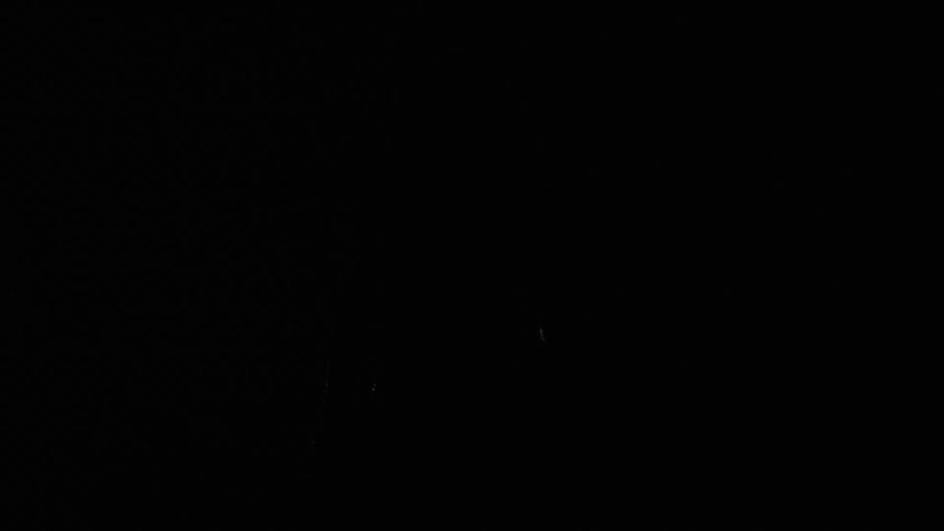 A muscular man with long hair stands defiantly in the middle of a heavy downpour illuminated by a bright backlight that cuts through the darkness the blackandwhite cinematography emphasizes the glistening water droplets against his skin and the intens