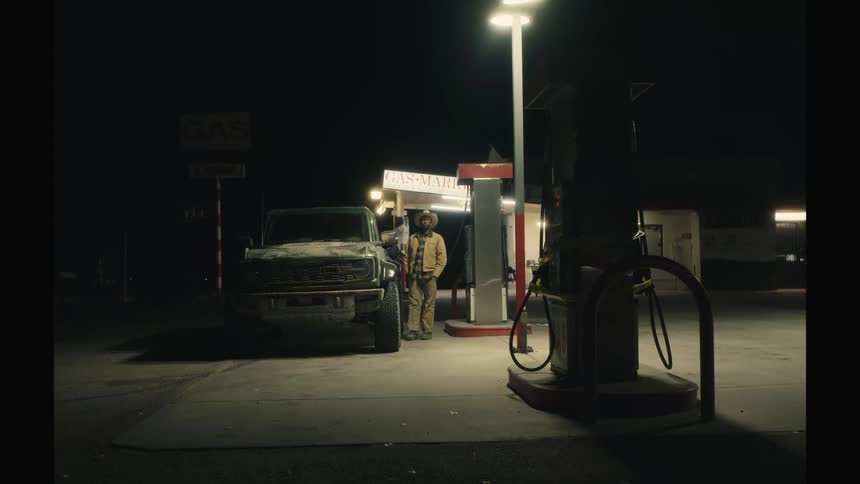 Man standing next to his truck getting gas at the gas station