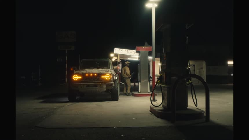 A man exits his jeep at begins to pump gas at a gas station