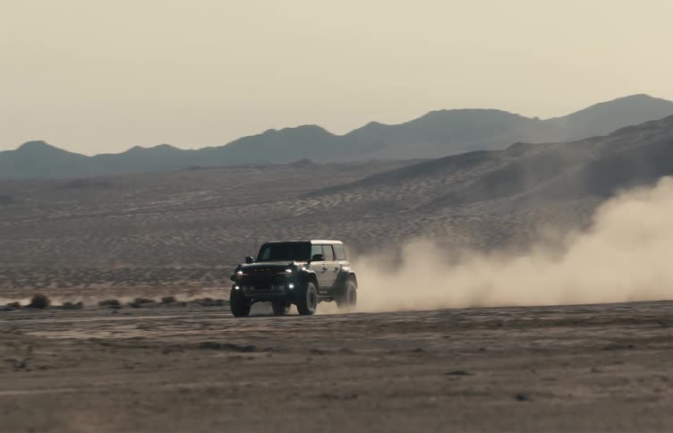 Jeep traveling fast through the desert leaving a trail of dust behind
