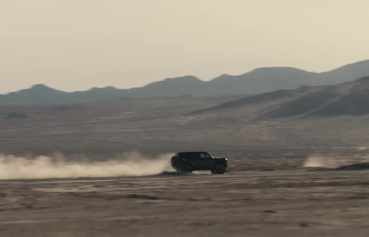 A person driving a vehicle out in the middle of the desert