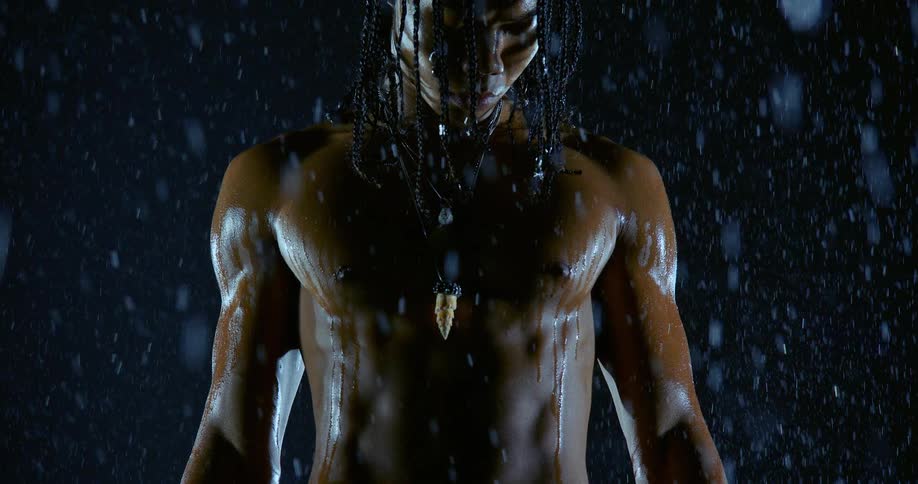 A man standing outdoors in the rain at night