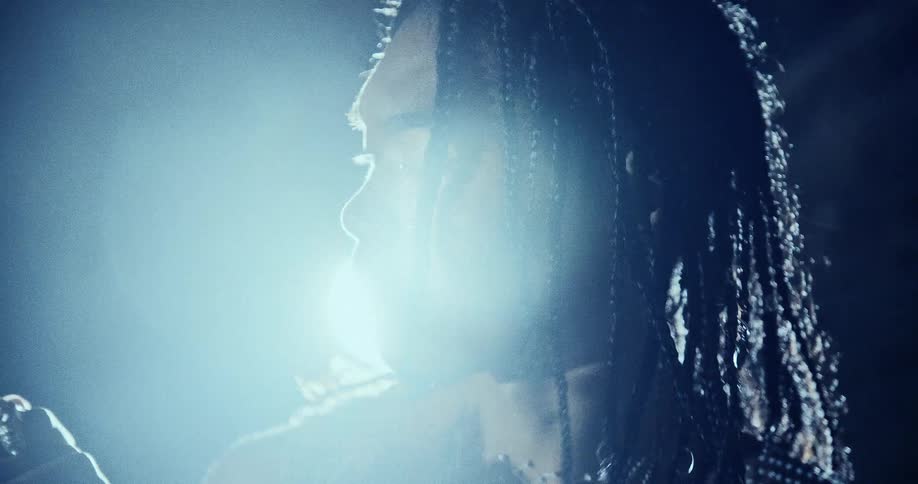 A person standing outdoors in front of a light at night