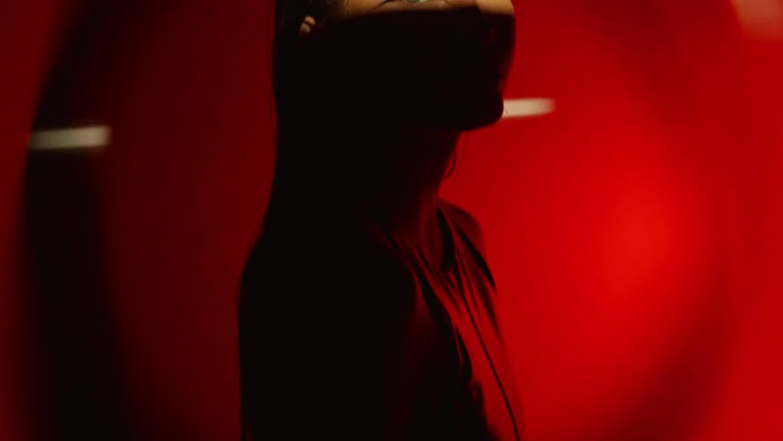 The woman is posing in the dark room