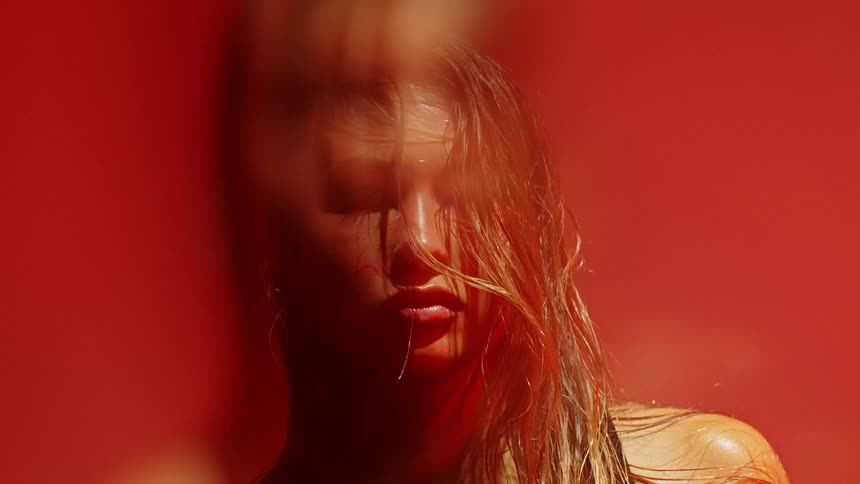 Woman with wet hair against illuminated red background