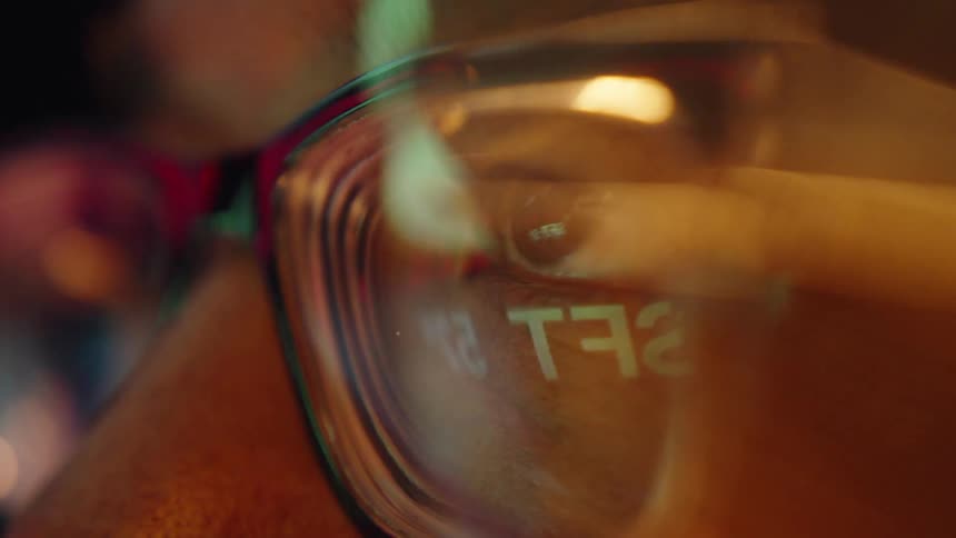 Reflection of numbers on eyeglass lens under warm lighting
