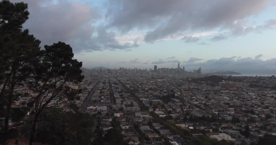 An elevated wide view of a city and its skyline at dusk