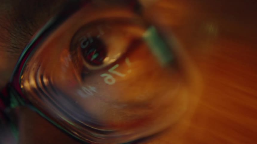 Eye seen through glasses with numbers reflected on the lens