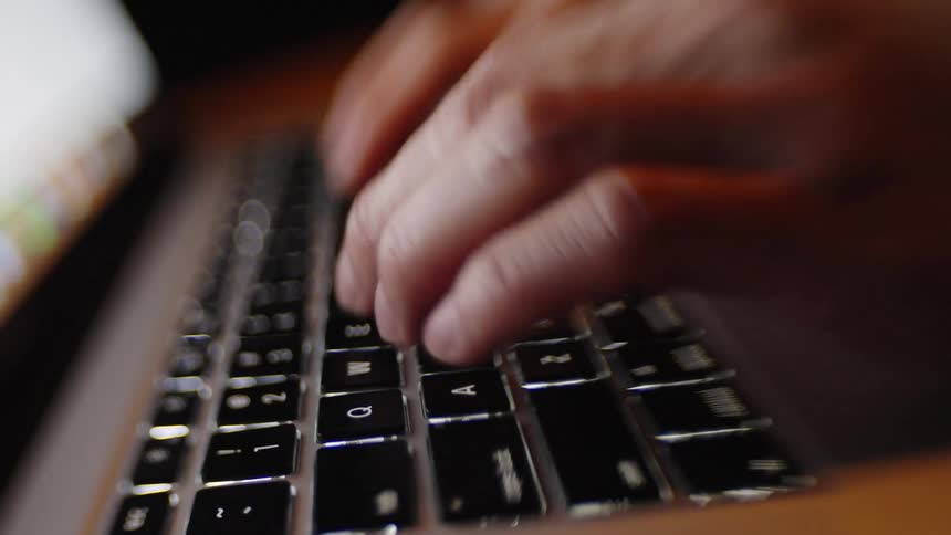 The man is typing on the laptop