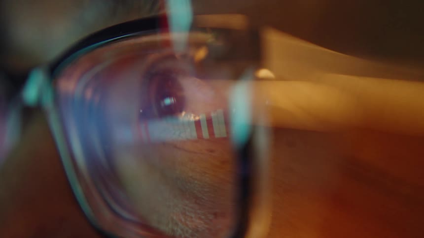 Reflection of an illuminated screen in an eye behind glasses