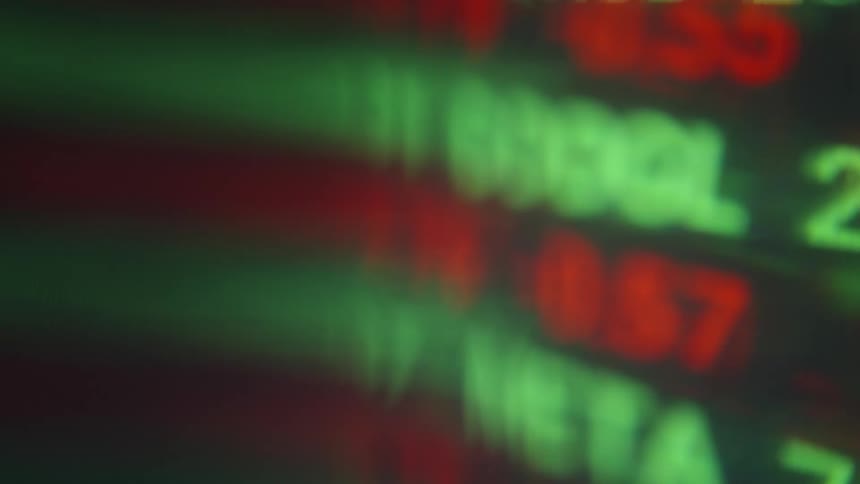 Blurred green letters and numbers on a screen indoors