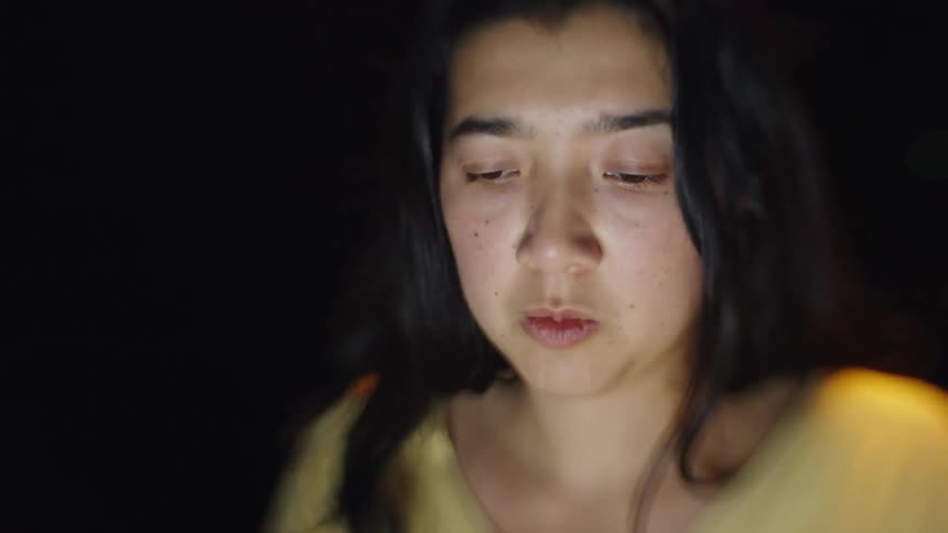 Young adult woman sitting with a nervous facial expression indoors