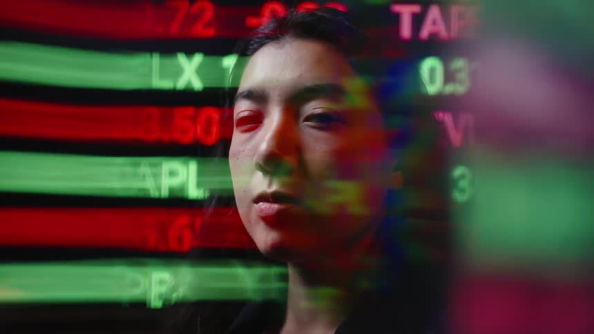 The video shows a womans face superimposed with fastmoving stock market tickers and financial data it creates a sense of intensity or immersion within the highstakes world of global trading