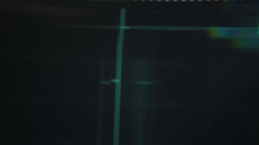 Abstract view of a glowing digital stock market chart with green and red lines moving against a dark background while purple and orange light flares streak across the screen