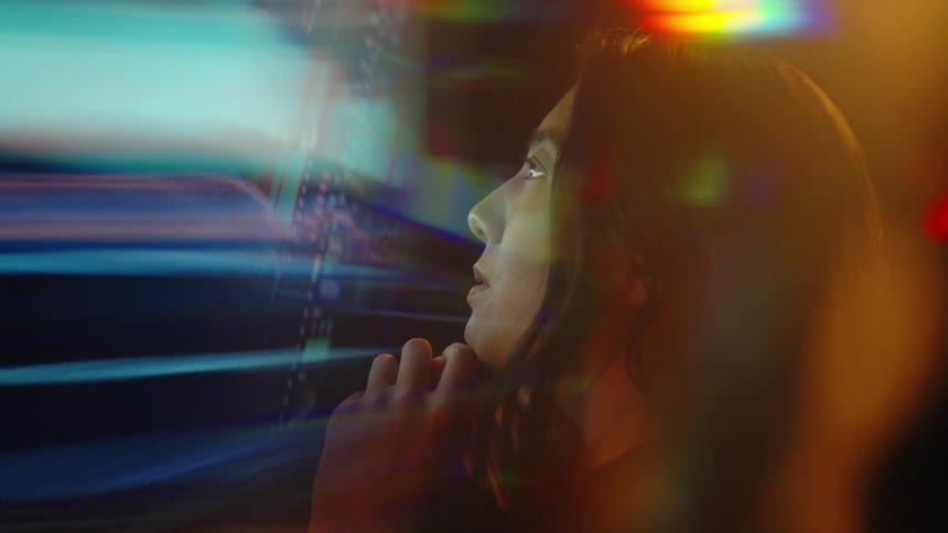 Side profile of woman focused on screen with multicolored charts