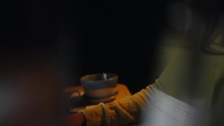 The woman is typing in the dark room