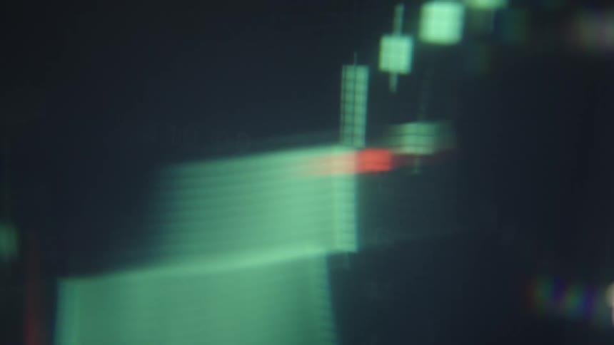 Financial candlestick chart on a screen indoors