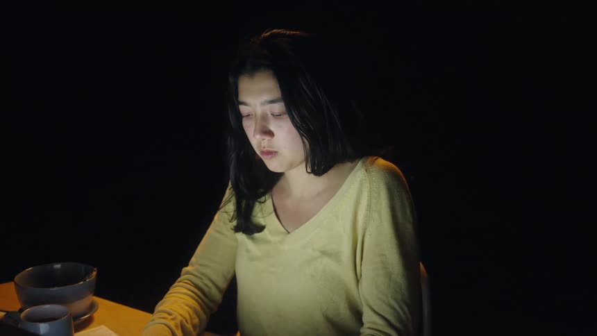 The woman types on her laptop at the desk