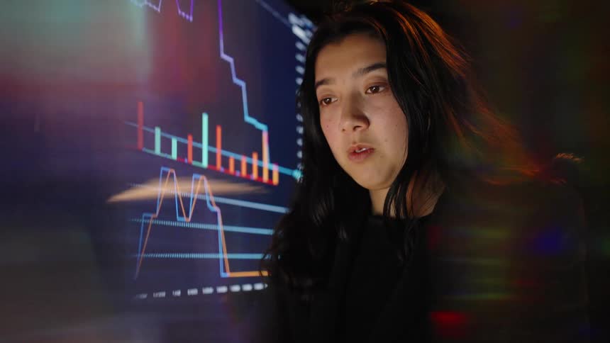 A woman looking at screens in a room