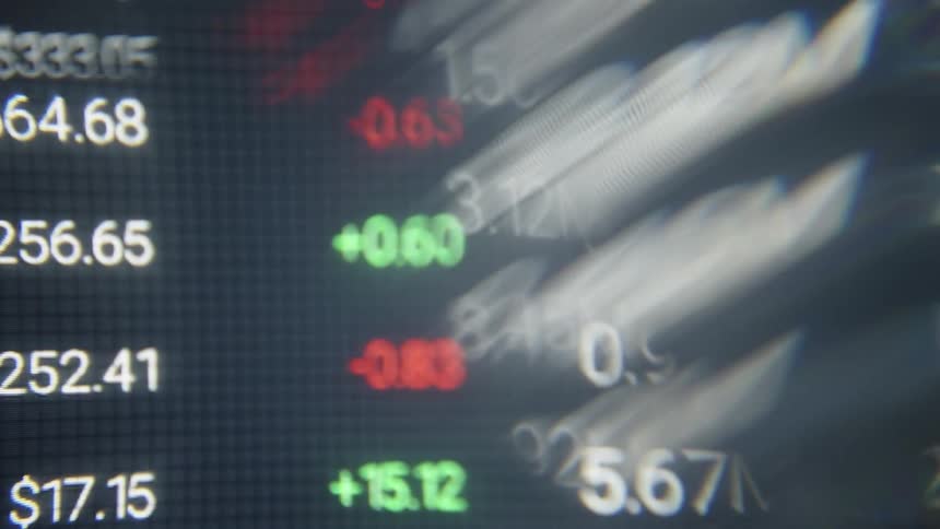 A rapid distorted pan across a financial monitor displays a flurry of stock symbols and fluctuating dollar amounts with bright green and red indicators shimmering through a heavy fisheye lens effect