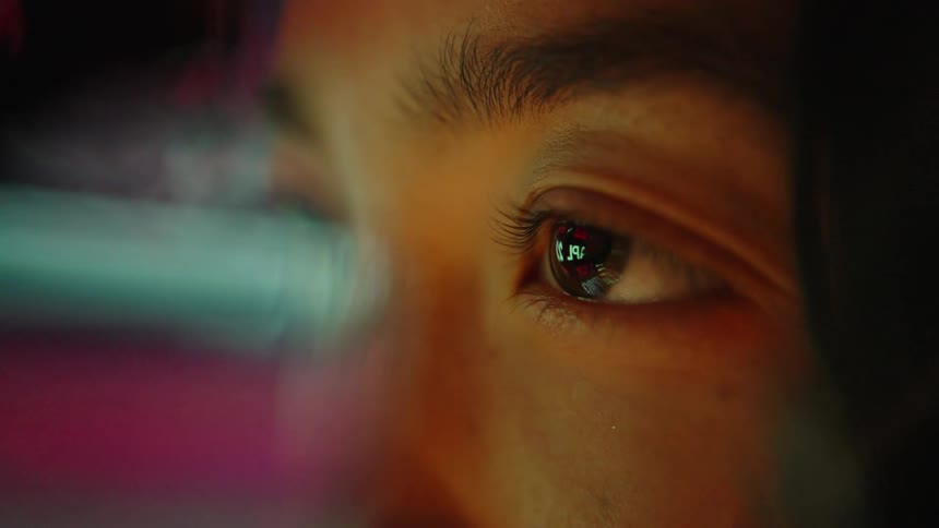 A close up of an eye reflecting digital data