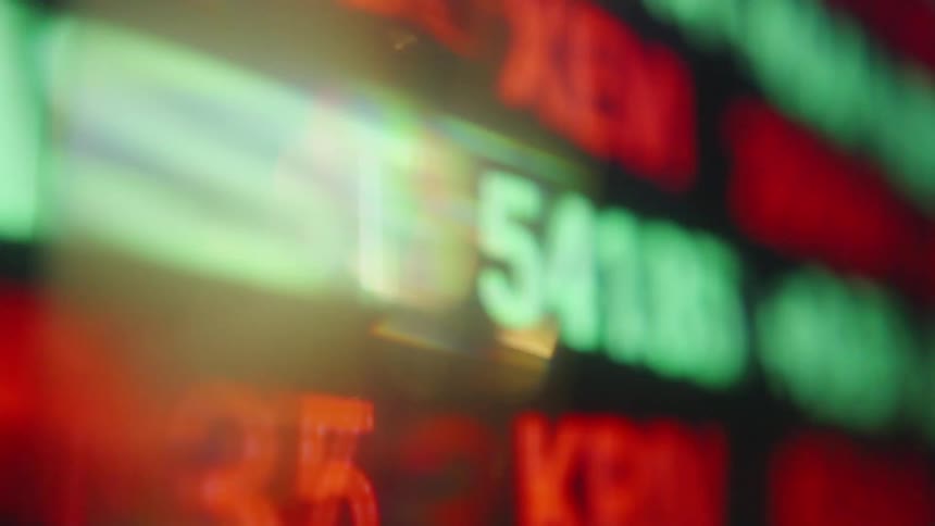Red and green numbers displayed with blur on a financial board
