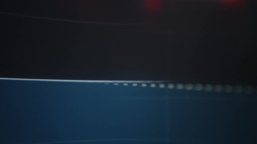 Bright orange and deep blue lines rapidly fluctuate and travel across a dark digital screen forming an active data graph that eventually shifts and blurs into soft luminous colors and abstract shapes