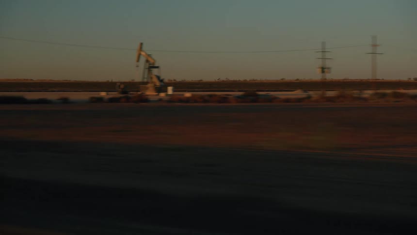 Oilfield equipment working on the side of a rural road