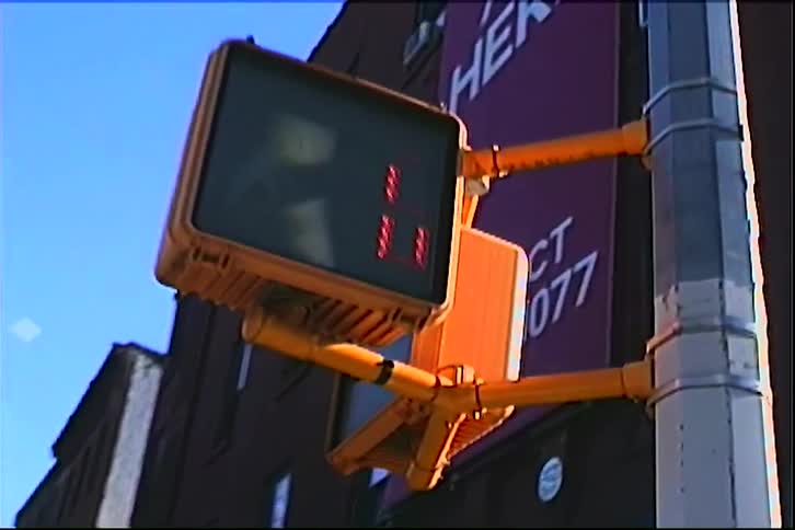 A pedestrian crossing signal displays a countdown timer and a red hand symbol