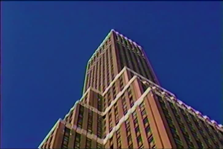 The tall building reaches up into the blue sky