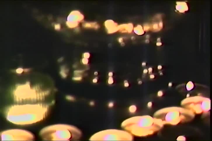Lit candles blurred illuminate a dark environment