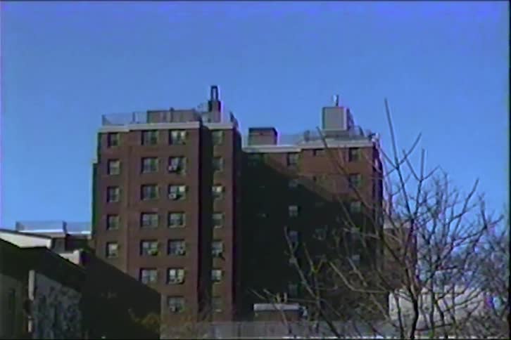 A multistory residential building in the city with leafless trees on a winter day