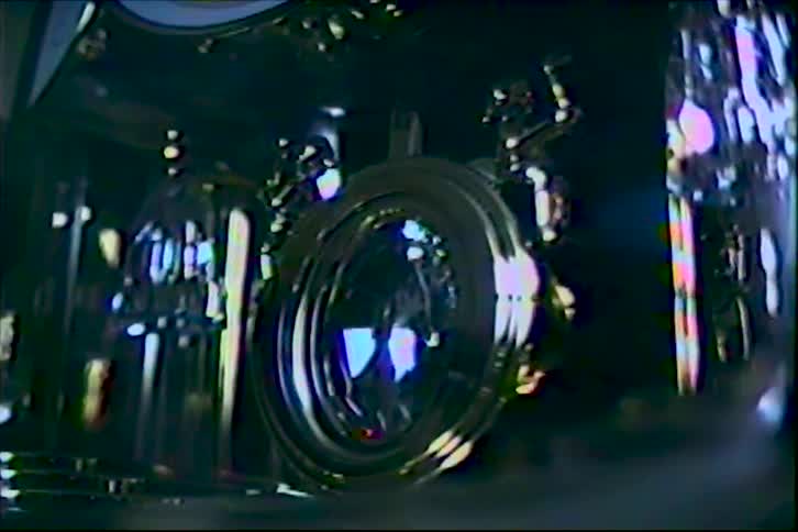 The light reflects off the lens of the swaying machine