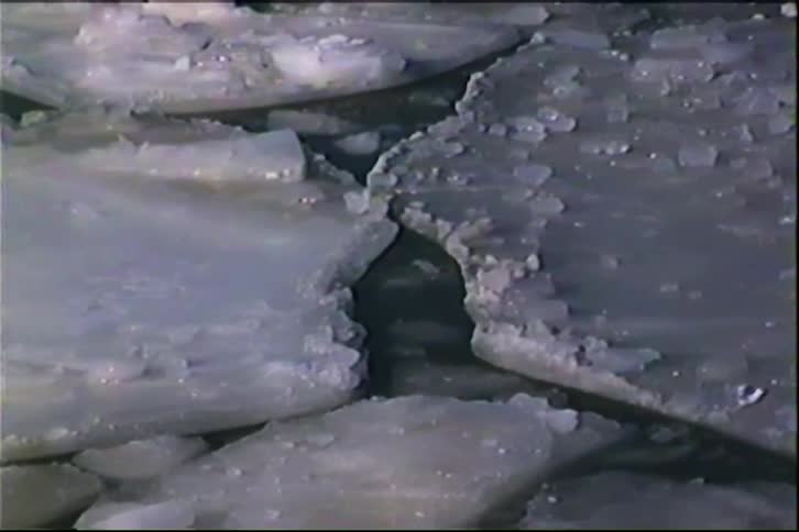 Broken ice sheets floating on dark water