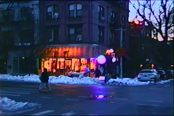 People hurry to cross a street in the city with snow on the ground