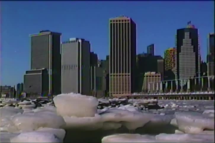 A city skyline at midday with the ocean frozen in the foreground ice floating on the surface during winter