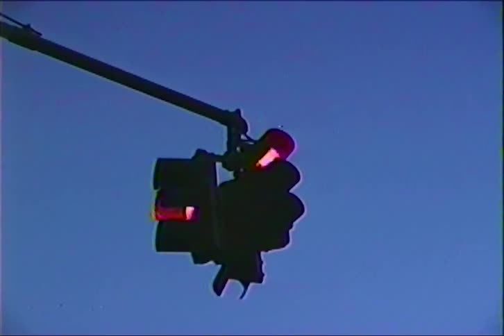 Traffic light with green signal illuminated against a blue sky