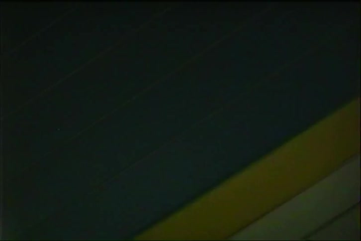 Lights flash during a trip through a tunnel with a wall containing white and yellow as well as gray rows