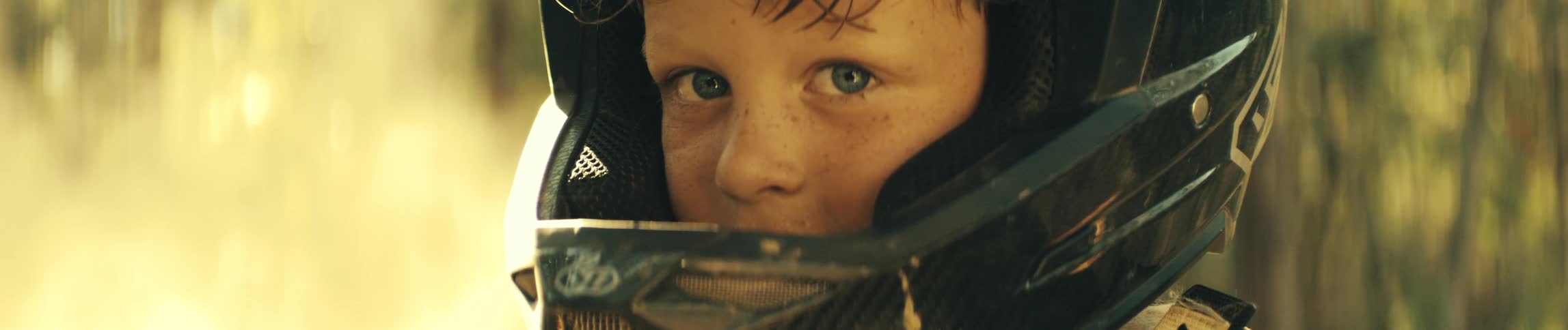A child wearing a helmet outdoors