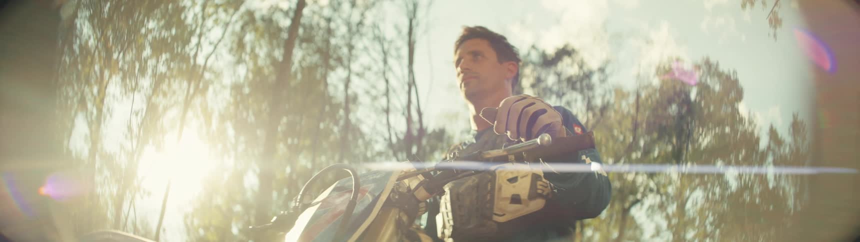 Man sits on a motorcycle in the woods