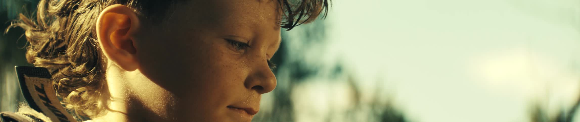 The child smiles and looks to the side