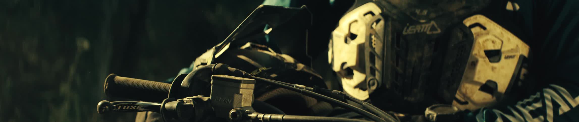 An up close look at a person holding a helmet near a dirt bike motor
