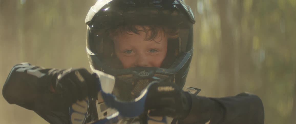 Boy removes protective cover from motocross helmet