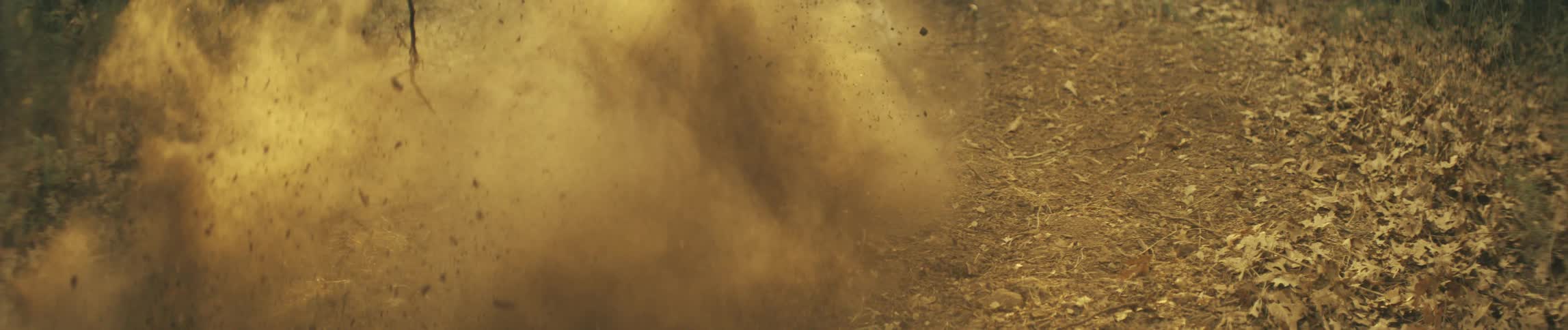 The dirt bike kicks up rocks as it speeds by