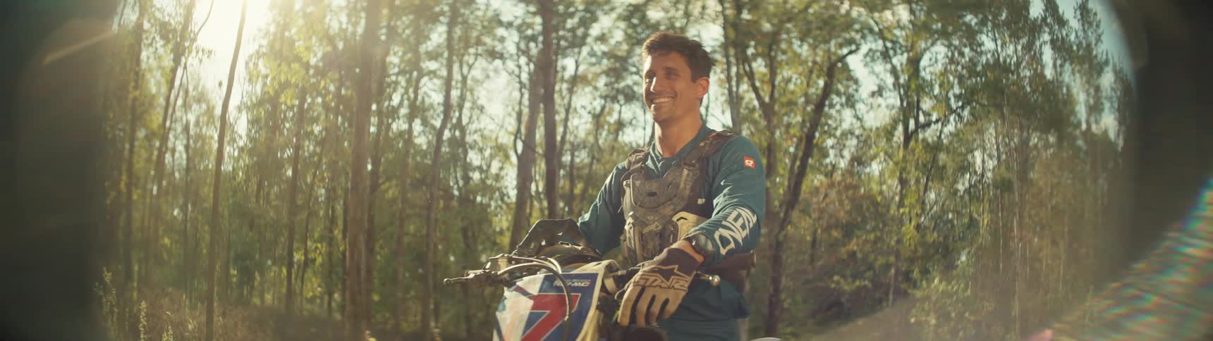 A man sitting on a dirt bike in a forest