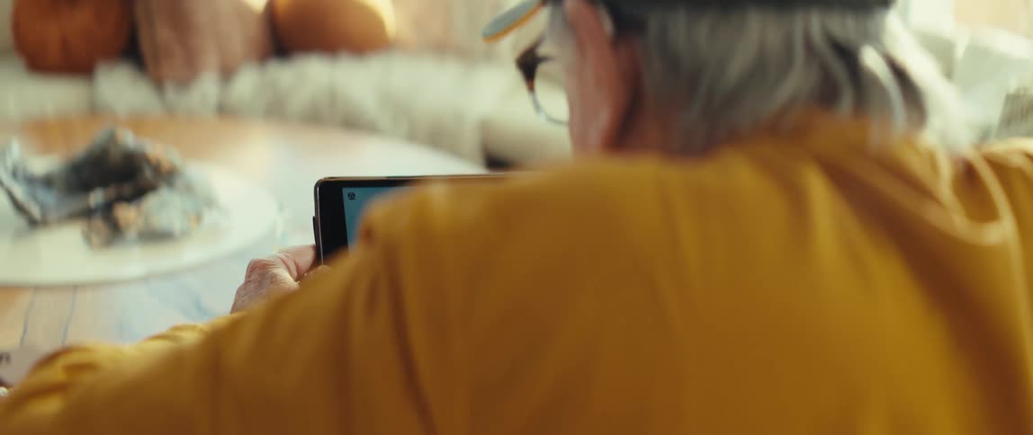 Man sitting down holding a tablet computer gets excited